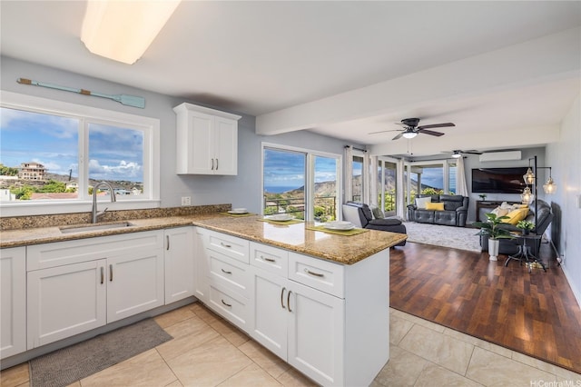 1048 Kaupaku Pl, Honolulu, HI 96825 - kitchen featuring a peninsula, white cabinetry, light stone countertops, light tile patterned flooring, and open floor plan