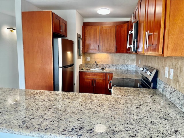 51-636 Kamehameha Hwy Unit 4412, Kaaawa, HI 96730 - kitchen featuring stainless steel appliances, decorative backsplash, light stone counters, and brown cabinets