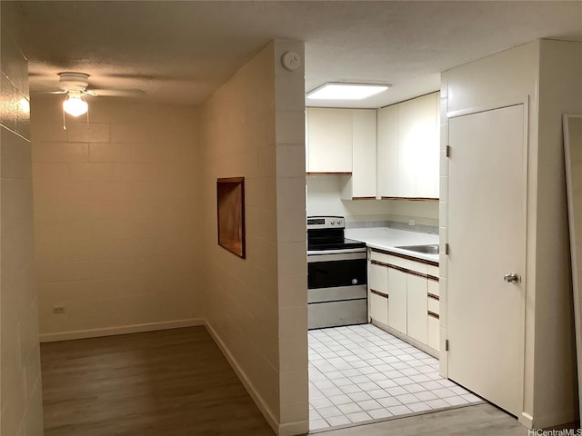 1330 Wilder Ave Unit 219, Honolulu, HI 96822 - kitchen with stainless steel electric range, ceiling fan, white cabinets, light countertops, and light wood-style floors