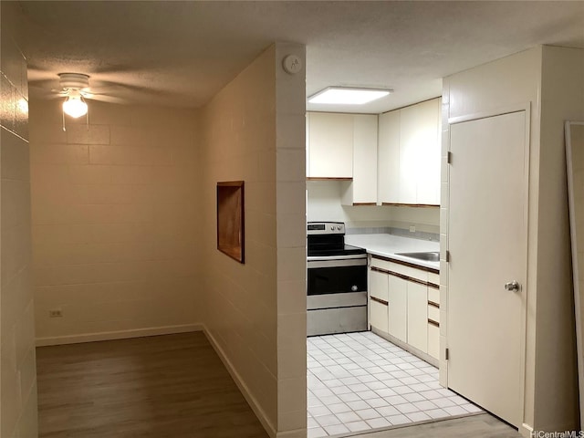 1330 Wilder Ave Unit 219, Honolulu, HI 96822 - kitchen featuring stainless steel electric stove, ceiling fan, white cabinetry, and light countertops