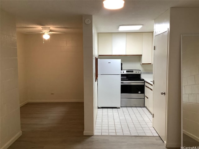 1330 Wilder Ave Unit 219, Honolulu, HI 96822 - kitchen with electric range, freestanding refrigerator, ceiling fan, light wood-style flooring, and white cabinets