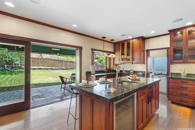 1371 Hele St, Kailua, HI 96734 - kitchen featuring wine cooler, crown molding, wood finished floors, an island with sink, and hanging light fixtures