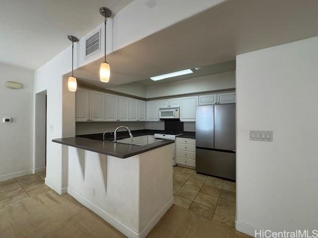 92-1055 Koio Dr Unit M36-6, Kapolei, HI 96707 - kitchen with white appliances, dark countertops, a peninsula, white cabinets, and hanging light fixtures