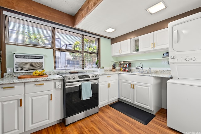 98-310 Kamehameha Hwy Unit 224, Aiea, HI 96701 - kitchen featuring stainless steel range with electric cooktop, stacked washer / dryer, light wood-style flooring, white cabinetry, and beamed ceiling
