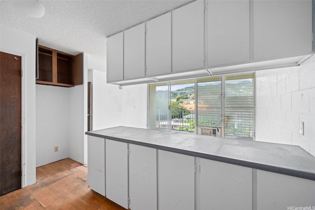 1687 Pensacola St Unit 1004, Honolulu, HI 96822 - kitchen featuring white cabinets and a textured ceiling