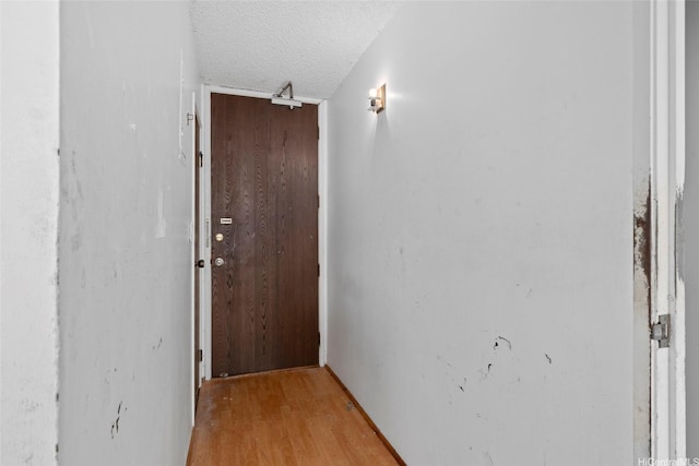 1687 Pensacola St Unit 1004, Honolulu, HI 96822 - hallway featuring a textured ceiling and light wood-type flooring