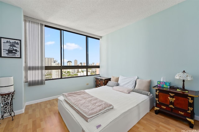 2499 Kapiolani Blvd Unit 2109, Honolulu, HI 96826 - bedroom with wood finished floors, a view of skyline, multiple windows, and a textured ceiling