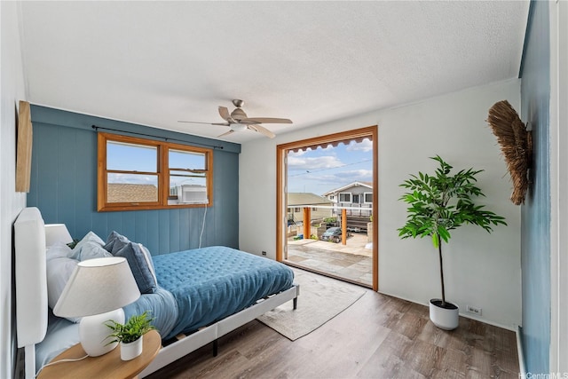 92-434 Kaiaulu St, Kapolei, HI 96707 - bedroom with access to outside, wood finished floors, ceiling fan, and a textured ceiling