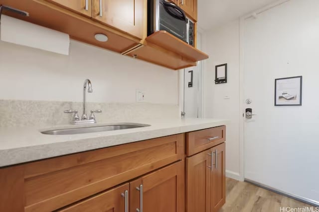 445 Seaside Ave Unit 3316, Honolulu, HI 96815 - kitchen featuring brown cabinetry, light wood-style flooring, light stone counters, and open shelves