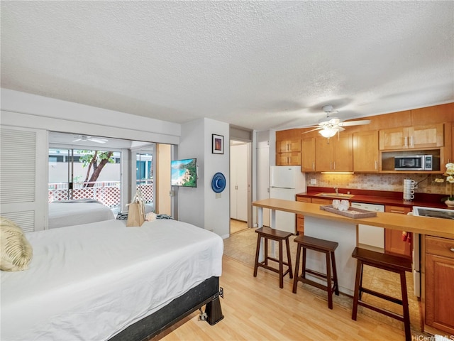 417 Nohonani St Unit 312, Honolulu, HI 96815 - bedroom with freestanding refrigerator, access to exterior, a textured ceiling, and light wood finished floors