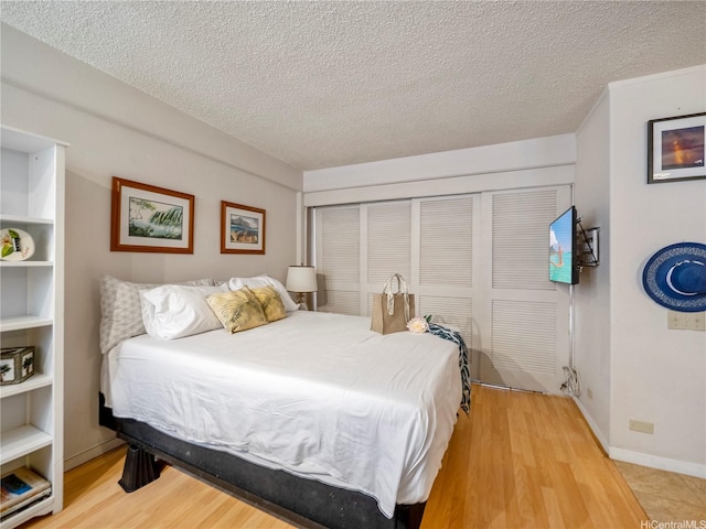 417 Nohonani St Unit 312, Honolulu, HI 96815 - bedroom featuring a textured ceiling, wood finished floors, and a closet