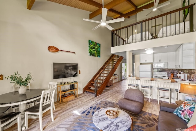 57-101 Kuilima Dr Unit 44, Kahuku, HI 96731 - living area featuring ceiling fan, light wood-style floors, stairway, beamed ceiling, and a towering ceiling