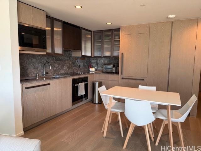 1000 Auahi St Unit 403, Honolulu, HI 96814 - kitchen with black appliances, a kitchen bar, modern cabinets, decorative backsplash, and recessed lighting