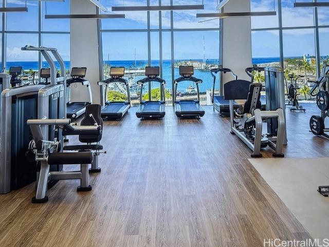 1000 Auahi St Unit 403, Honolulu, HI 96814 - exercise room featuring expansive windows, plenty of natural light, wood finished floors, a high ceiling, and a water view
