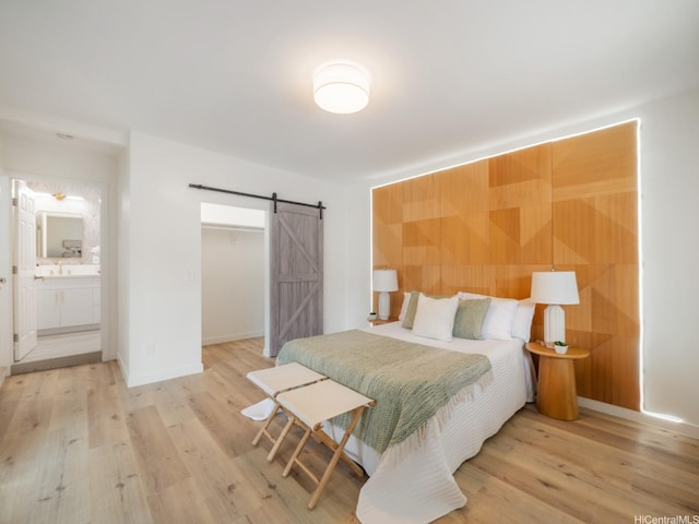 45-343 Namoku St Unit 343, Kaneohe, HI 96744 - bedroom featuring a barn door, light wood finished floors, a closet, a spacious closet, and wood walls