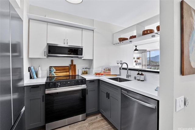 322 Aoloa St Unit 1708, Kailua, HI 96734 - kitchen featuring stainless steel appliances, gray cabinetry, light countertops, light wood-style flooring, and white cabinets