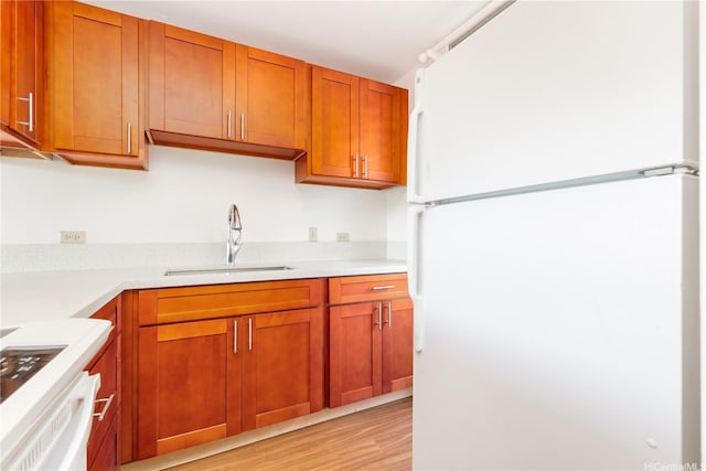 3030 Ala Ilima St Unit 402, Honolulu, HI 96818 - kitchen with freestanding refrigerator, light countertops, light wood-style floors, brown cabinets, and range