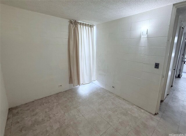 751 Kinau St Unit Dh20, Honolulu, HI 96813 - unfurnished room featuring concrete block wall and a textured ceiling