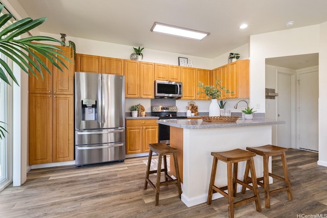 91-1221 Kanela St Unit M54, Ewa Beach, HI 96706 - kitchen featuring stainless steel appliances, a breakfast bar area, wood finished floors, a peninsula, and recessed lighting