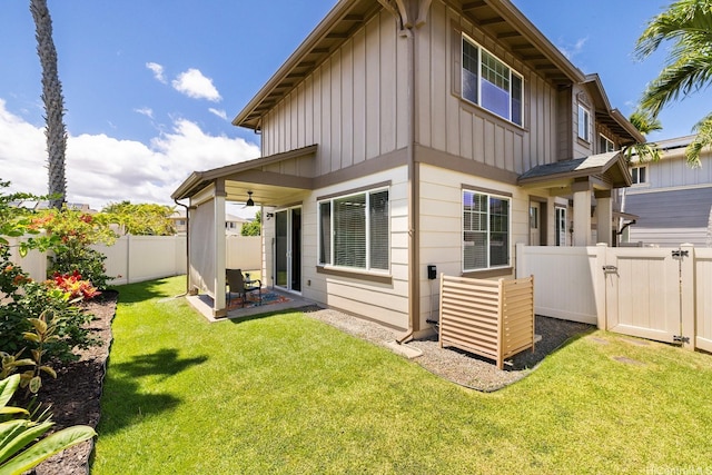 91-1221 Kanela St Unit M54, Ewa Beach, HI 96706 - rear view of property featuring board and batten siding, ceiling fan, and a fenced backyard