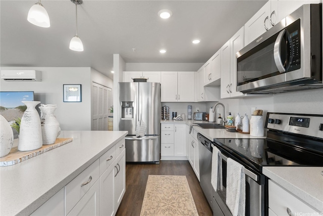 91-3475 Nana Hope St Unit 601, Ewa Beach, HI 96706 - kitchen with appliances with stainless steel finishes, an AC wall unit, dark wood-style floors, light countertops, and white cabinetry