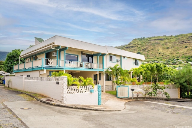 5216 Hao Pl, Honolulu, HI 96821 - view of front facade featuring a balcony, a ceiling fan, stucco siding, and a gate
