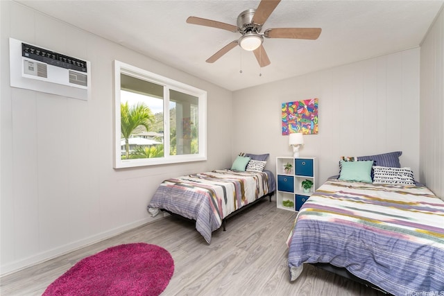 5216 Hao Pl, Honolulu, HI 96821 - bedroom with light wood finished floors, a ceiling fan, and an AC wall unit
