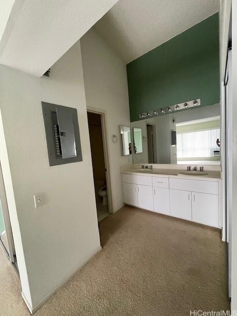 91-1020 Laaulu St Unit 27C, Ewa Beach, HI 96706 - full bathroom with electric panel, double vanity, high vaulted ceiling, and carpet flooring