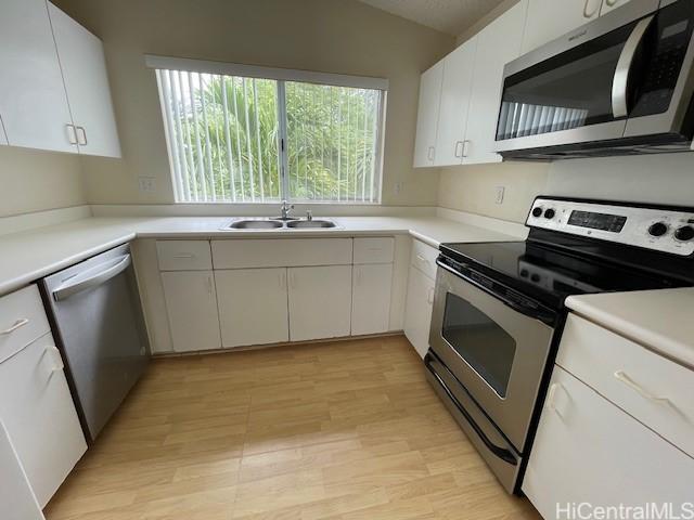 91-1020 Laaulu St Unit 27C, Ewa Beach, HI 96706 - kitchen featuring stainless steel appliances, white cabinetry, light countertops, light wood finished floors, and vaulted ceiling