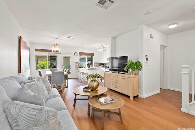 91-1312 Keoneula Blvd Unit 203, Ewa Beach, HI 96706 - living room featuring light wood-style flooring and a chandelier