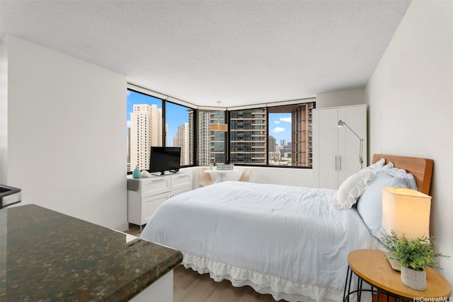 444 Niu St Unit 2403, Honolulu, HI 96815 - bedroom featuring wood finished floors and a textured ceiling