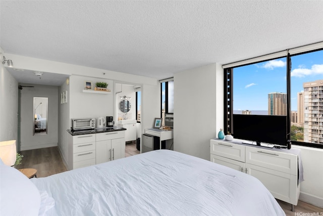 444 Niu St Unit 2403, Honolulu, HI 96815 - bedroom featuring light wood-type flooring and a textured ceiling