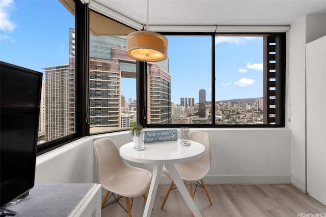 444 Niu St Unit 2403, Honolulu, HI 96815 - dining area featuring wood finished floors, a skyline view, plenty of natural light, and a textured ceiling