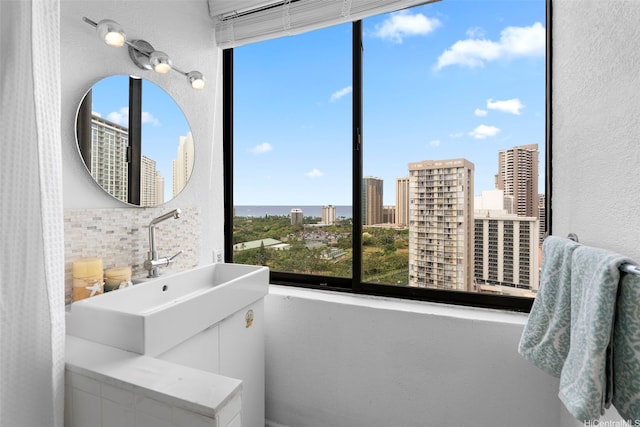 444 Niu St Unit 2403, Honolulu, HI 96815 - bathroom featuring healthy amount of natural light, backsplash, a view of city, a textured wall, and vanity