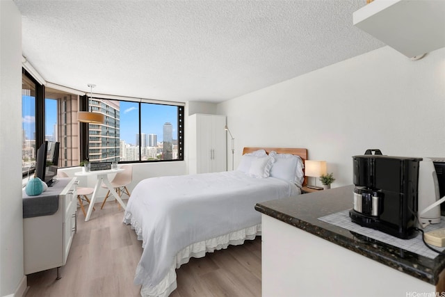 444 Niu St Unit 2403, Honolulu, HI 96815 - bedroom featuring light wood finished floors and a textured ceiling