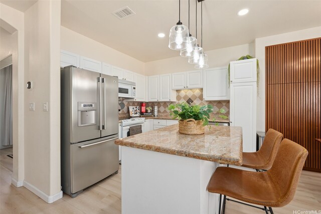 91-1021 Kaileolea Dr Unit H3, Ewa Beach, HI 96706 - kitchen with white appliances, a kitchen island, white cabinets, light stone counters, and recessed lighting