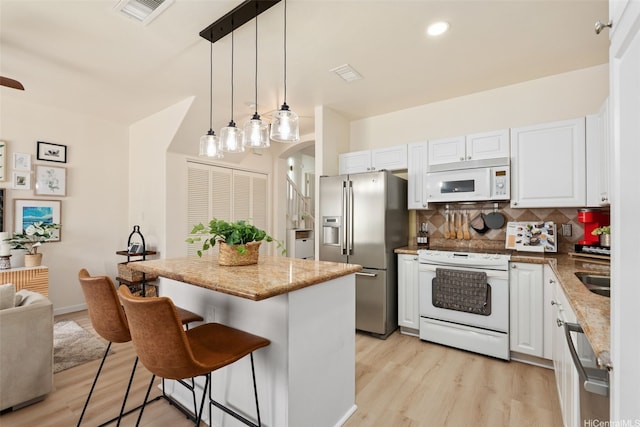 91-1021 Kaileolea Dr Unit H3, Ewa Beach, HI 96706 - kitchen featuring stainless steel appliances, light wood-style floors, tasteful backsplash, white cabinetry, and recessed lighting