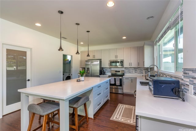 91-1886 Makahehi Loop, Ewa Beach, HI 96706 - kitchen featuring appliances with stainless steel finishes, tasteful backsplash, washing machine and dryer, a kitchen island, and recessed lighting