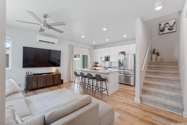 91-1641 Honouliuli St Unit 42, Ewa Beach, HI 96706 - living room with a wall mounted air conditioner, stairs, light wood-style flooring, recessed lighting, and a ceiling fan