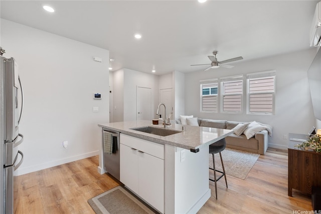 91-1641 Honouliuli St Unit 42, Ewa Beach, HI 96706 - kitchen with appliances with stainless steel finishes, a center island with sink, white cabinetry, a ceiling fan, and a breakfast bar area