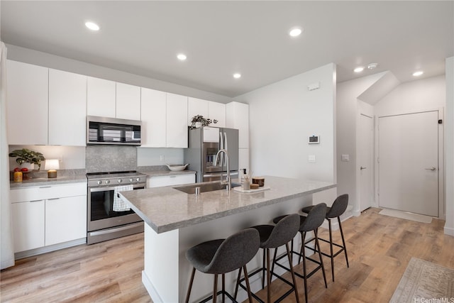 91-1641 Honouliuli St Unit 42, Ewa Beach, HI 96706 - kitchen with stainless steel appliances, a kitchen breakfast bar, an island with sink, recessed lighting, and white cabinets