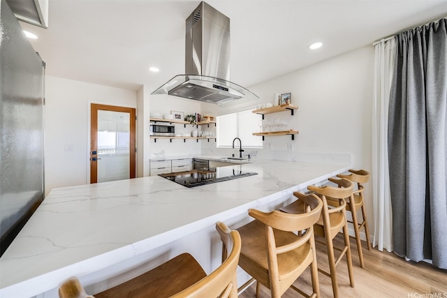 3795 Anuhea St, Honolulu, HI 96816 - kitchen with island range hood, open shelves, stainless steel microwave, light wood finished floors, and light stone countertops