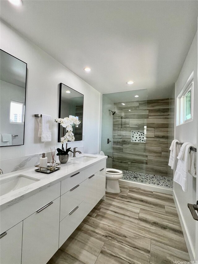 1689 Lewalani Dr, Honolulu, HI 96822 - bathroom featuring double vanity, a stall shower, plenty of natural light, recessed lighting, and wood finished floors