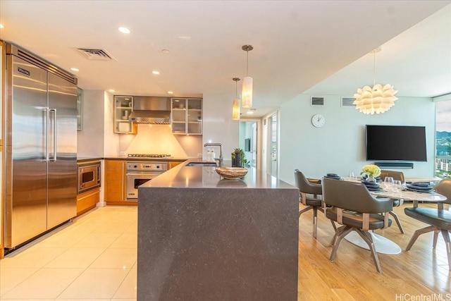 1177 Queen St Unit 3401, Honolulu, HI 96814 - kitchen with built in appliances, glass insert cabinets, pendant lighting, dark countertops, and recessed lighting