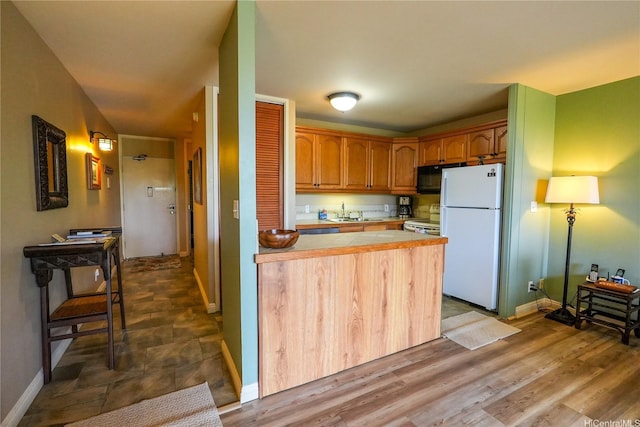 57-101 Kuilima Dr Unit 189, Kahuku, HI 96731 - kitchen featuring freestanding refrigerator, black microwave, electric stove, tile counters, and a peninsula