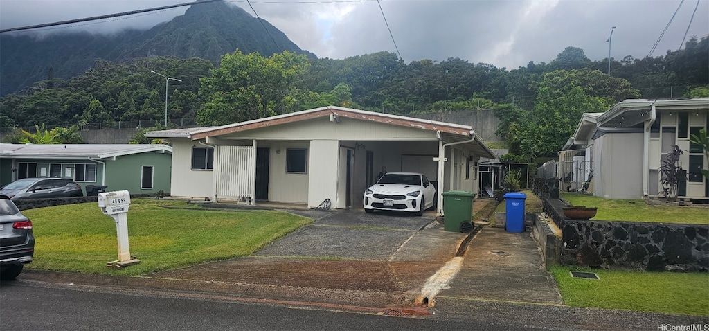 45-659 Kapunahala Rd, Kaneohe, HI 96744 - view of front of house featuring concrete driveway, a carport, a front yard, a wooded view, and a mountain view