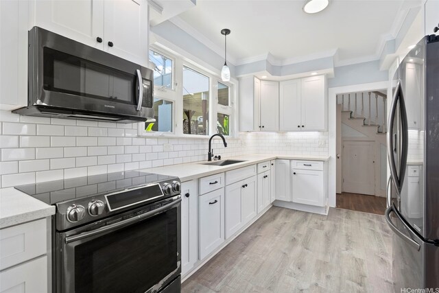 1186 Alewa Dr, Honolulu, HI 96817 - kitchen with appliances with stainless steel finishes, crown molding, white cabinets, light wood-style flooring, and decorative backsplash