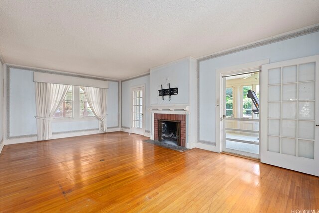 1186 Alewa Dr, Honolulu, HI 96817 - unfurnished living room with a textured ceiling, a brick fireplace, light wood-style floors, and ornamental molding