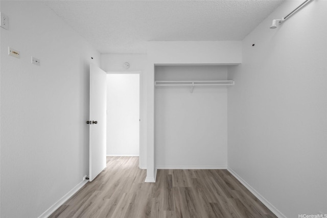 94-043 Keahilele St Unit 114, Mililani, HI 96789 - unfurnished bedroom with wood finished floors, a textured ceiling, and a closet
