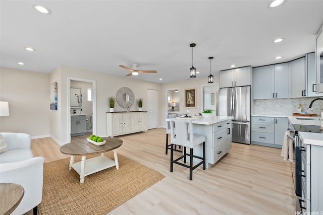 1076 Kahili St, Kailua, HI 96734 - kitchen with appliances with stainless steel finishes, a kitchen bar, light countertops, recessed lighting, and a center island